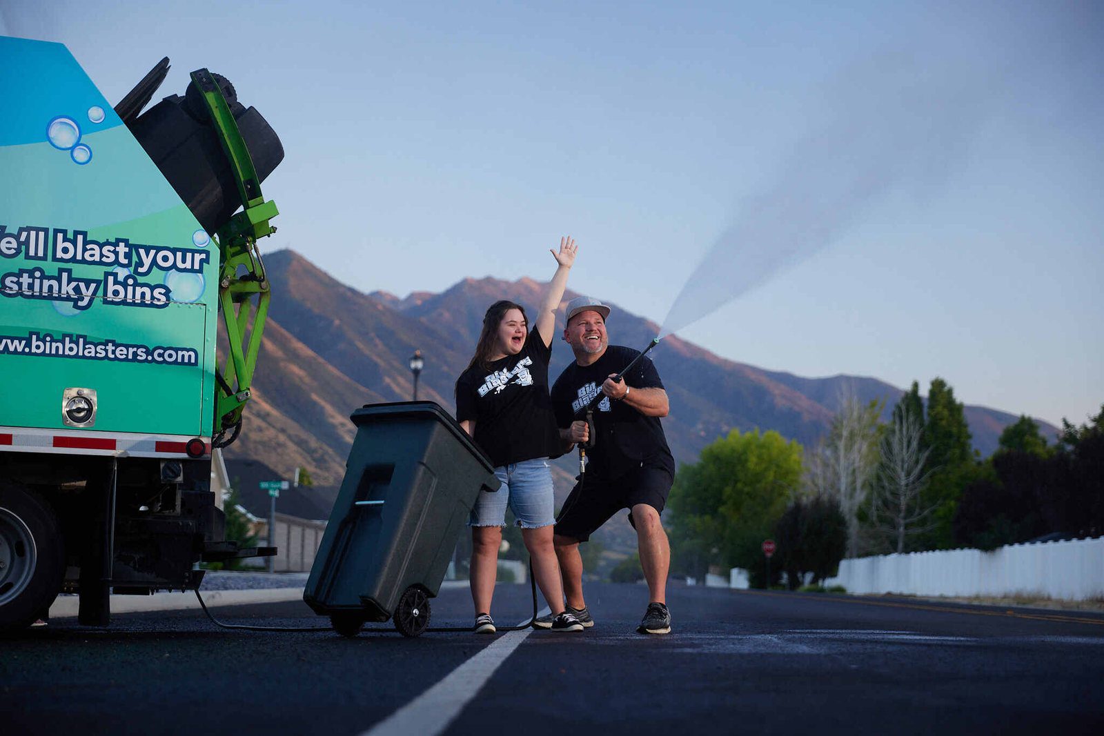 Bin Blasters owner and his daughter blasting a bin at the curb